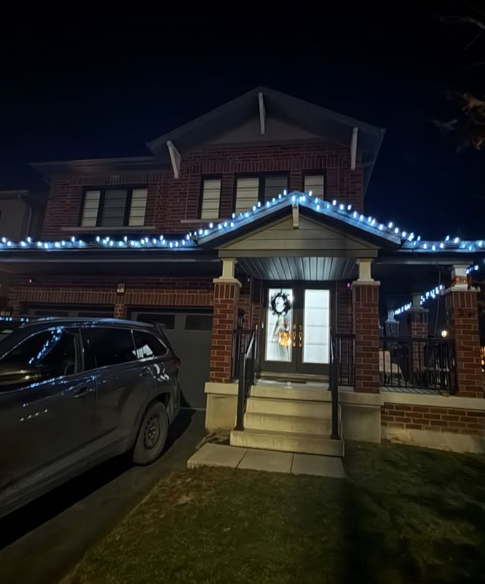 Home lit with professionally installed Christmas lights at dusk