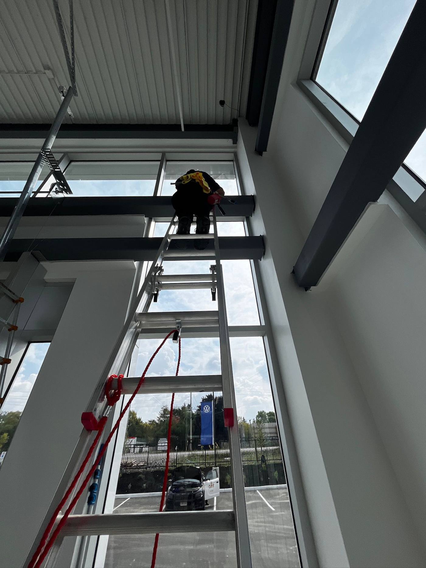 Ladder work on tall interior atrium glass