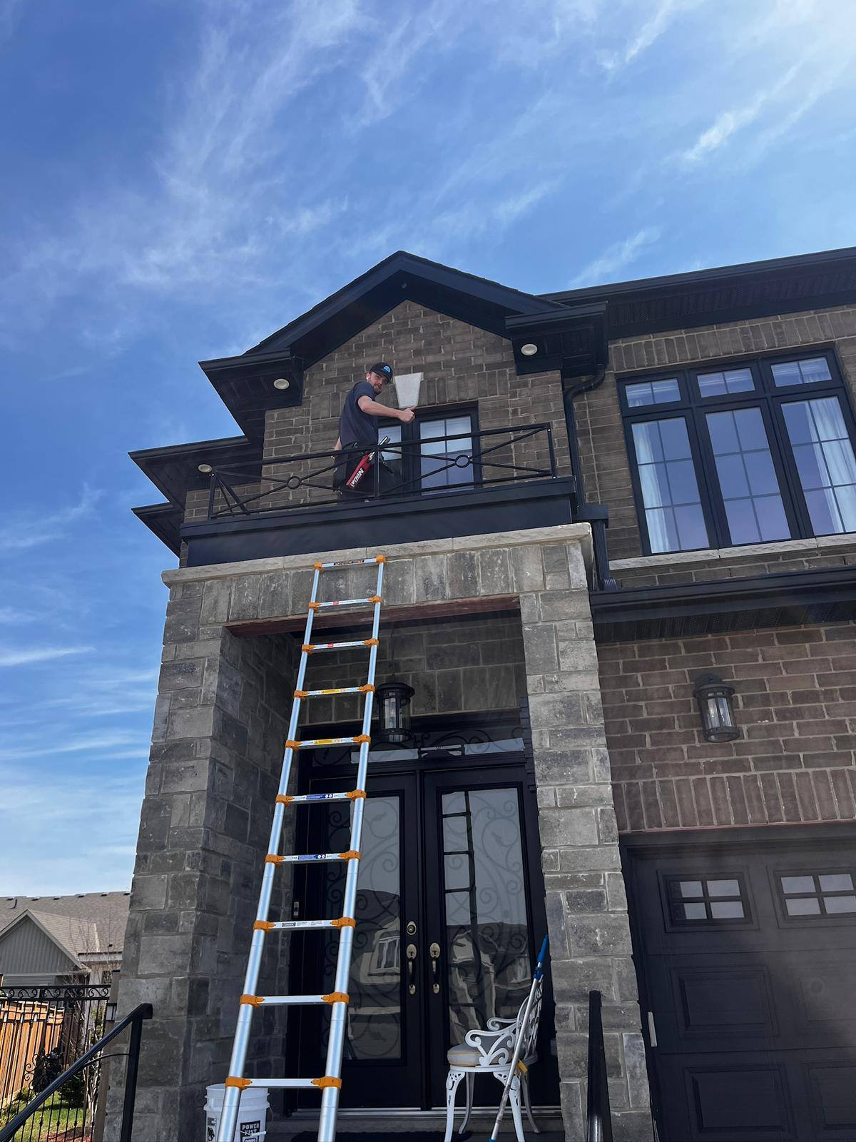 Extension ladder reaching the upper windows of a stone home