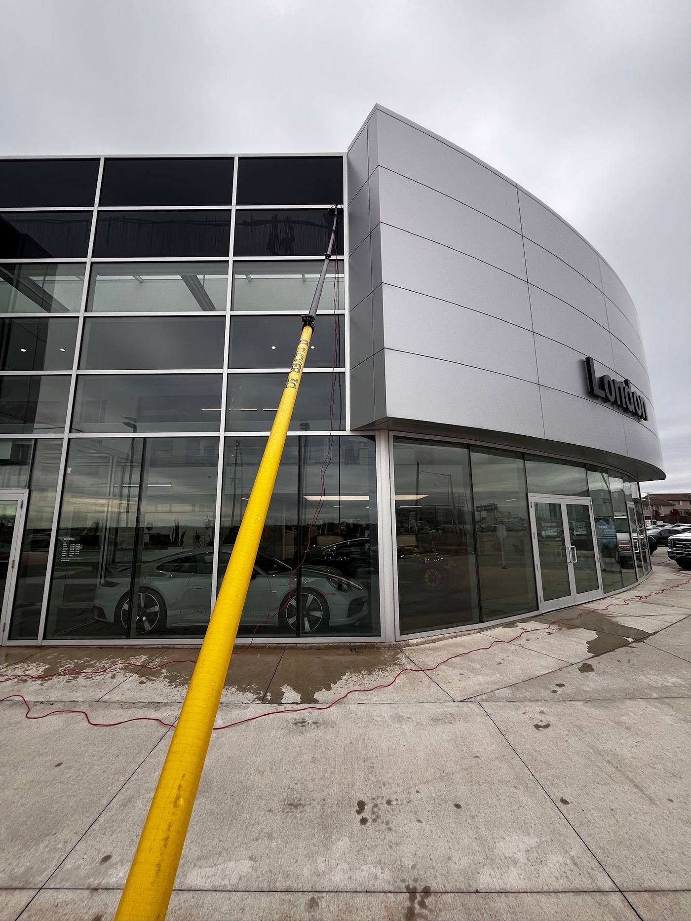 Water-fed pole reaching the upper glass at Porsche Centre London