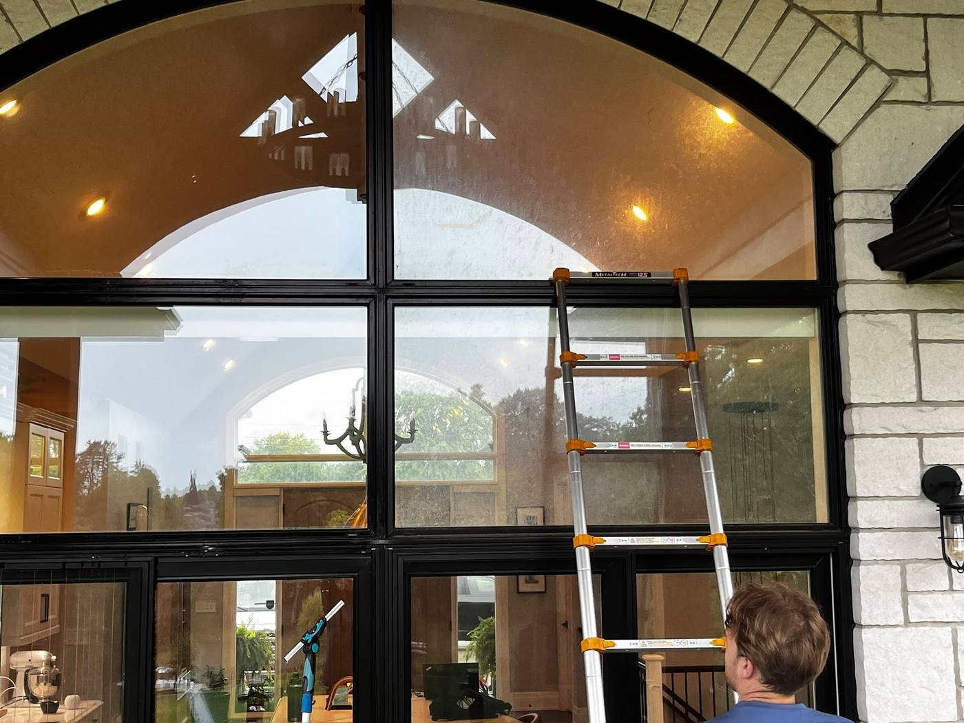 Ladder set up at a tall arched feature window