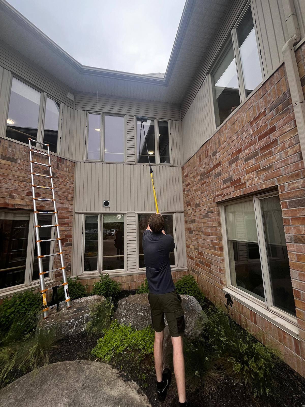 Pole and ladder work at a brick home