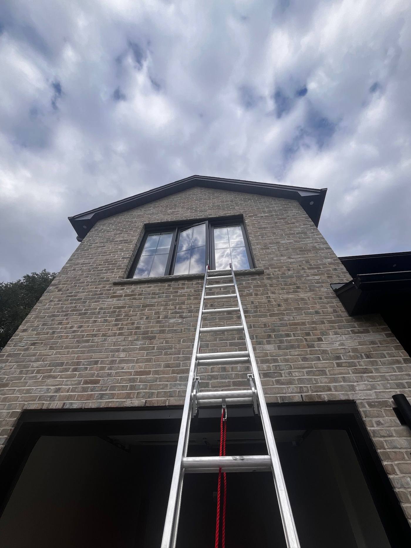 Tall ladder reaching the upper eaves of a stone home