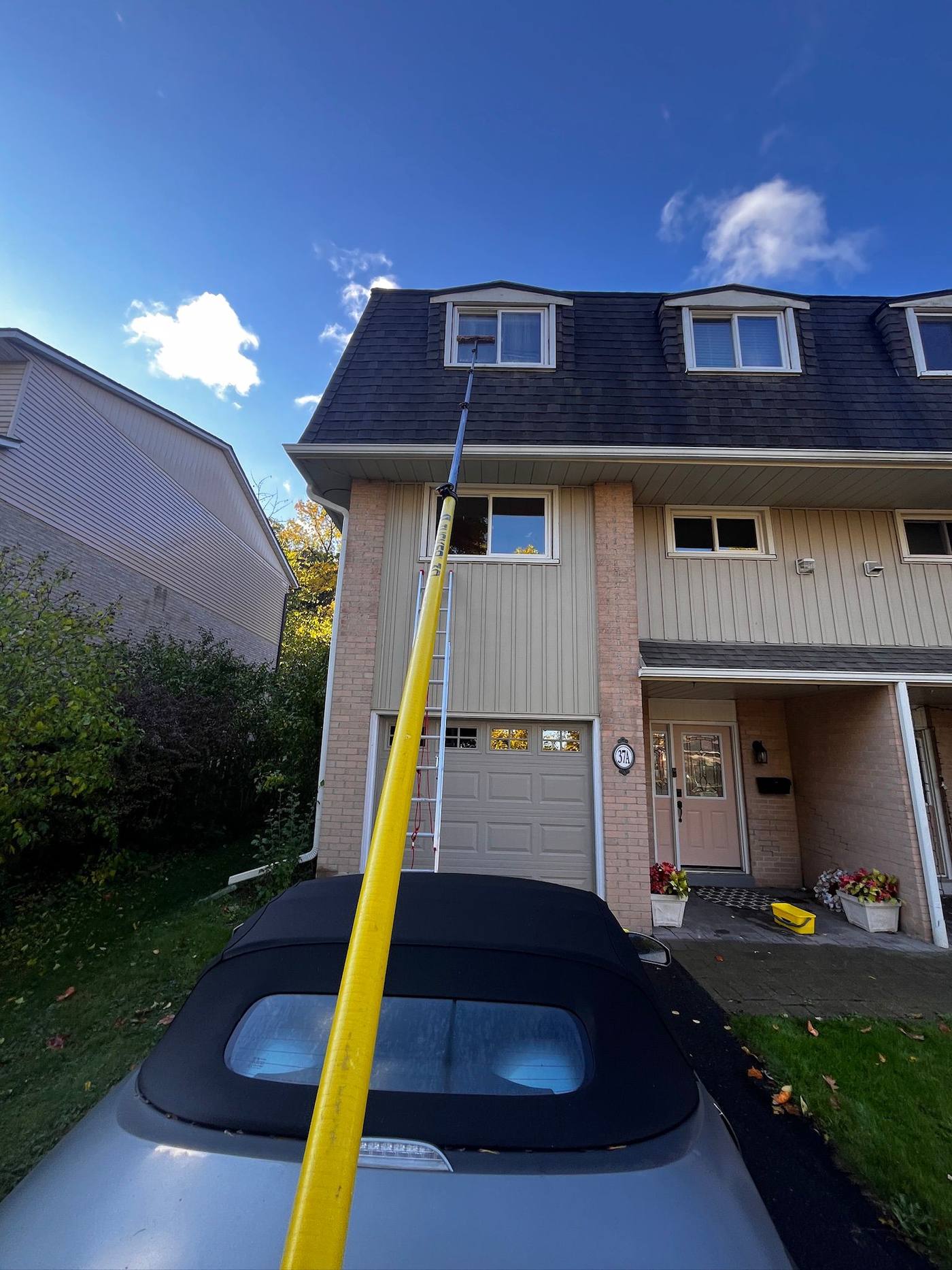 Cleaning townhouse windows from the driveway