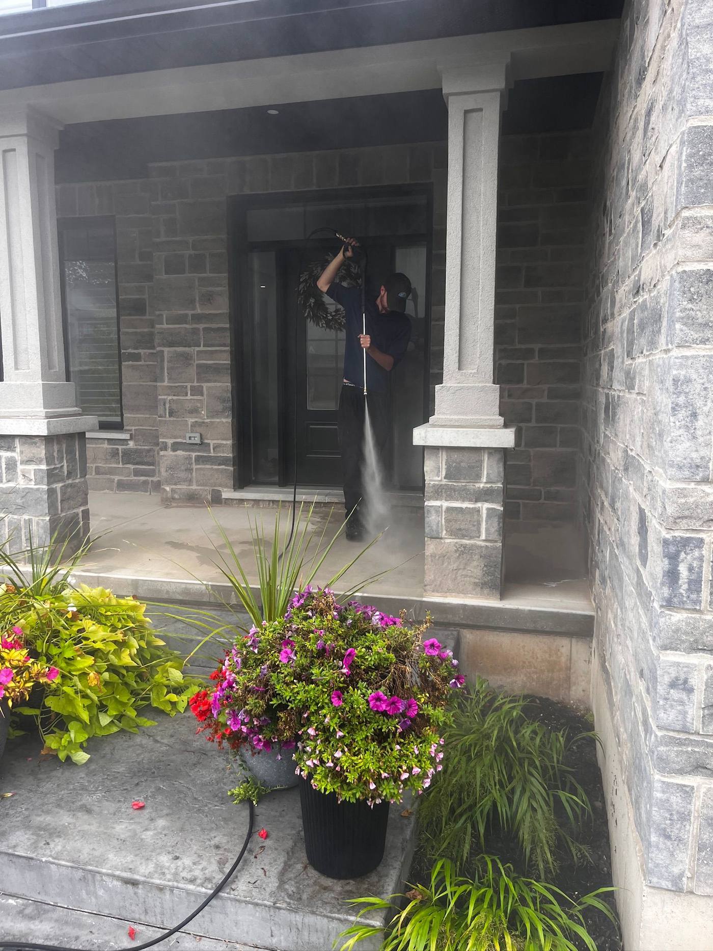 Pressure washing a stone porch and entryway