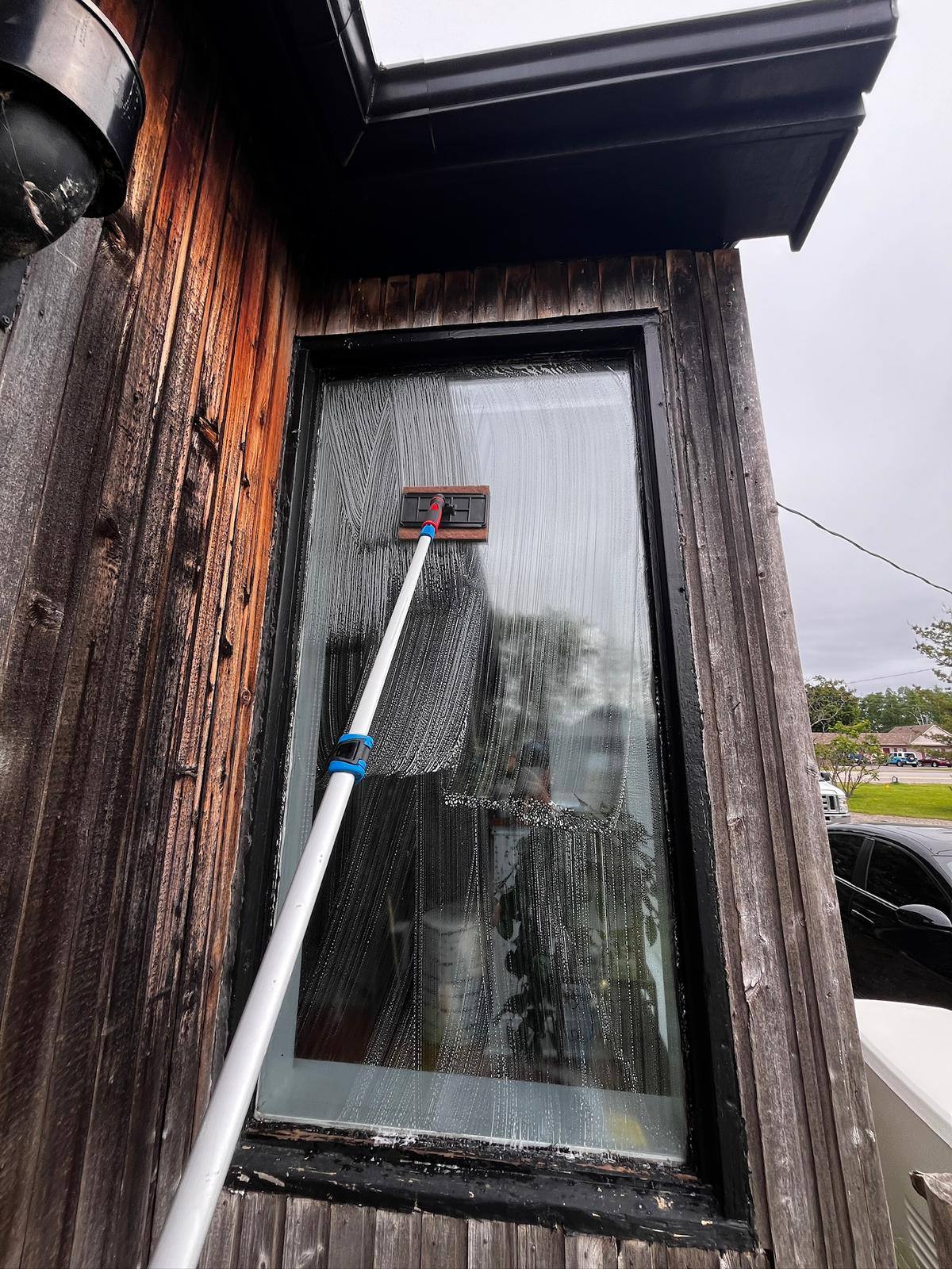 Squeegee on a window set into dark wood siding