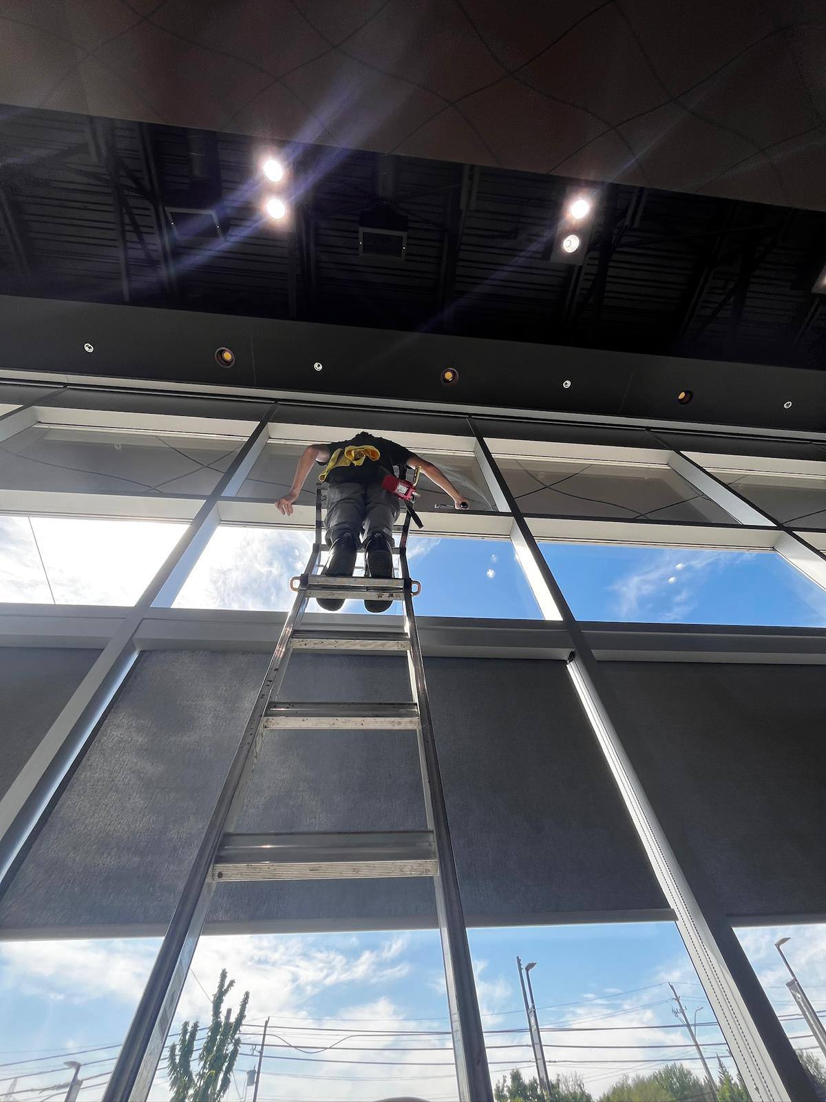 Cleaning sloped atrium glass from a ladder
