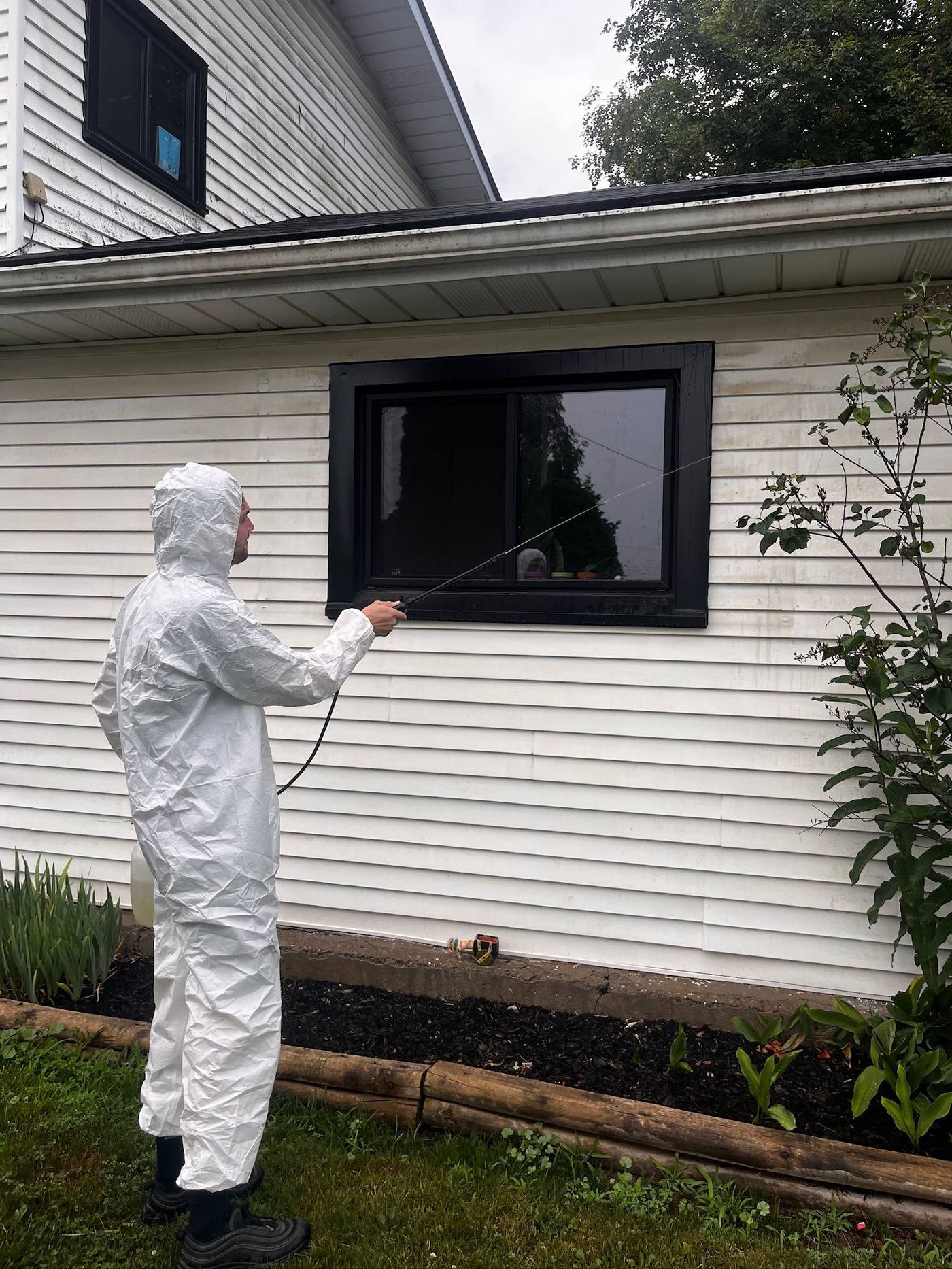 Low-pressure soft wash applied around a window and siding