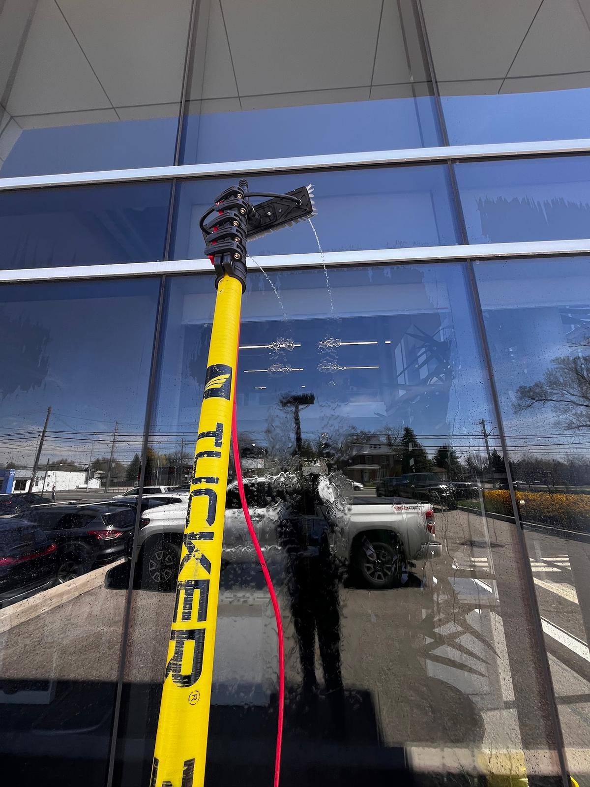 Water-fed pole on a reflective storefront window